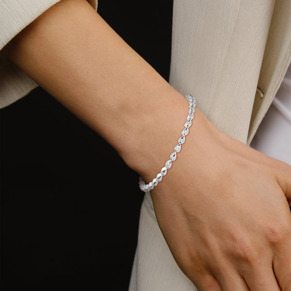 This luxurious tennis bracelet features 40 emerald-shaped diamonds, totaling 14.55 carats. With a 7-inch length, it offers an elegant, timeless design that adds exceptional brilliance to any occasion.