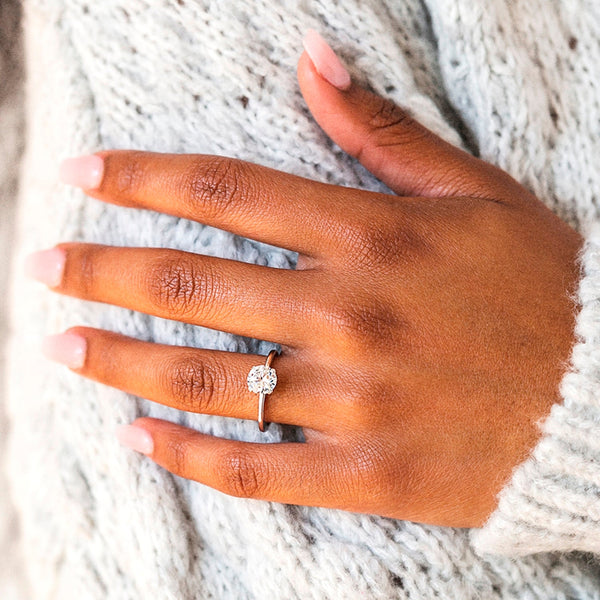 Elodie Whisper enchants with its delicate silhouette and double claw prongs that gently embrace a brilliant round diamond, floating effortlessly atop a slender white gold band.