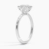 Elodie Whisper enchants with its delicate silhouette and double claw prongs that gently embrace a brilliant round diamond, floating effortlessly atop a slender white gold band.