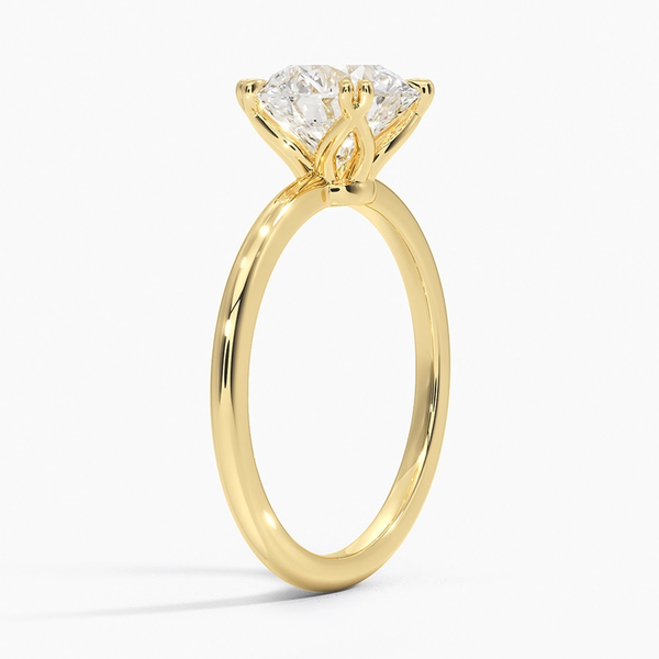 Elodie Whisper enchants with its delicate silhouette and double claw prongs that gently embrace a brilliant round diamond, floating effortlessly atop a slender white gold band.