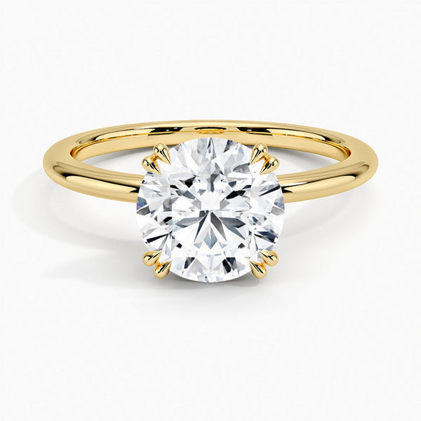 Elodie Whisper enchants with its delicate silhouette and double claw prongs that gently embrace a brilliant round diamond, floating effortlessly atop a slender white gold band.