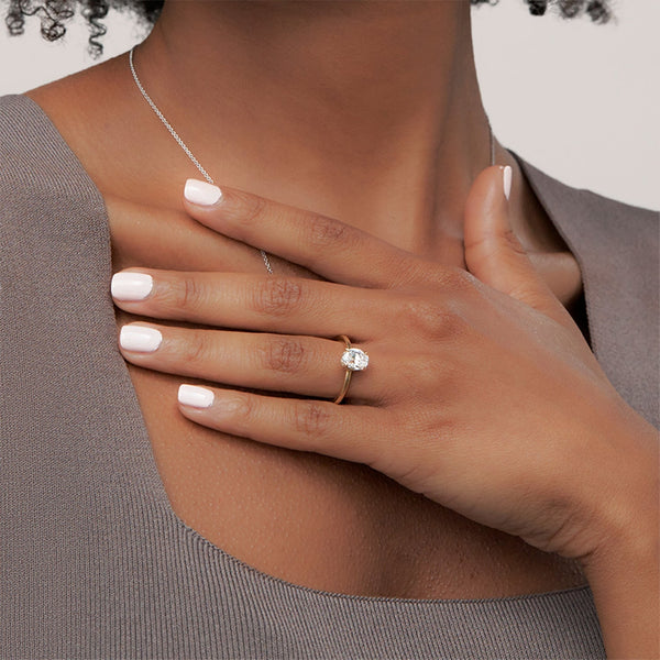 A round brilliant solitaire embraced by an intricate vine-inspired setting, intertwining elegance and organic artistry.