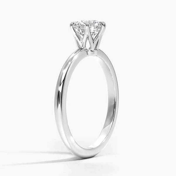 A refined solitaire ring featuring a round brilliant diamond held in a six-prong trellis setting, paired with a polished white gold band.