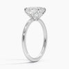Celestia Crest features a stunning oval diamond elevated by a hidden halo and intricate claw prongs, set atop a high-polish band for a flawless blend of sparkle and sophistication.