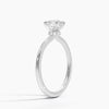 Celestia Crown radiates refined luxury, with a hidden halo of diamonds encircling the base of a dazzling round center stone in a sleek white metal setting.