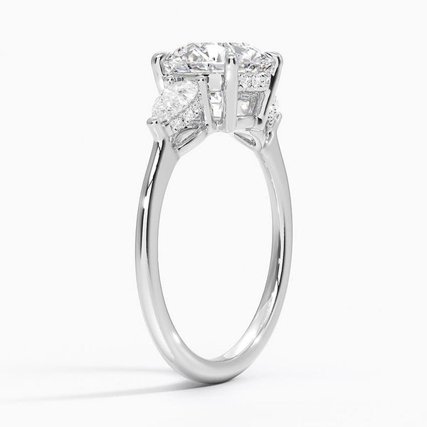 The Virelle Bloom ring features a brilliant round diamond flanked by marquise and pavé-set stones, evoking the soft, organic elegance of blossoming petals.