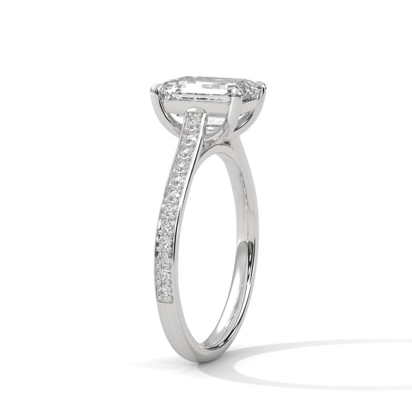 The Celestial Elegance Ring features a striking emerald-cut diamond embraced by a delicate band adorned with shimmering pave stones. A timeless piece that symbolizes everlasting love and sophistication.