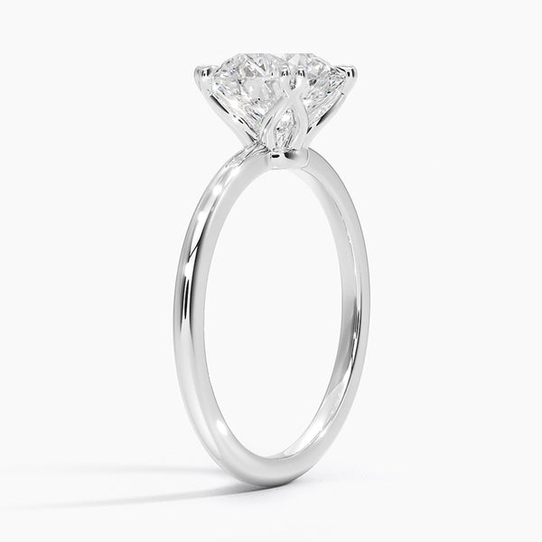 Elodie Whisper enchants with its delicate silhouette and double claw prongs that gently embrace a brilliant round diamond, floating effortlessly atop a slender white gold band.