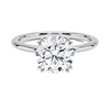 Elodie Whisper enchants with its delicate silhouette and double claw prongs that gently embrace a brilliant round diamond, floating effortlessly atop a slender white gold band.
