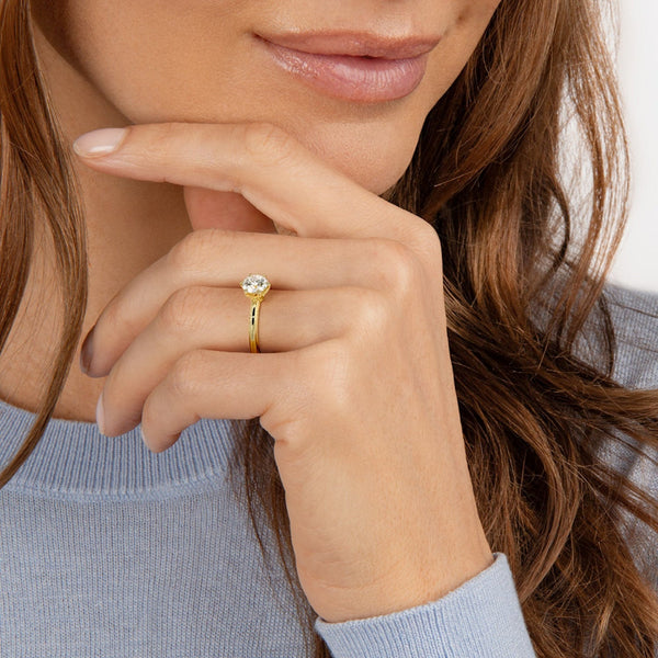 A refined solitaire ring featuring a round brilliant diamond held in a six-prong trellis setting, paired with a polished white gold band.