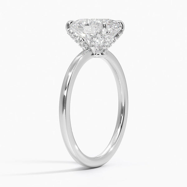 Celestia Crest features a stunning oval diamond elevated by a hidden halo and intricate claw prongs, set atop a high-polish band for a flawless blend of sparkle and sophistication.