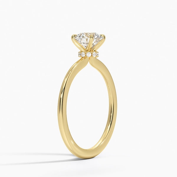 Celestia Crown radiates refined luxury, with a hidden halo of diamonds encircling the base of a dazzling round center stone in a sleek white metal setting.