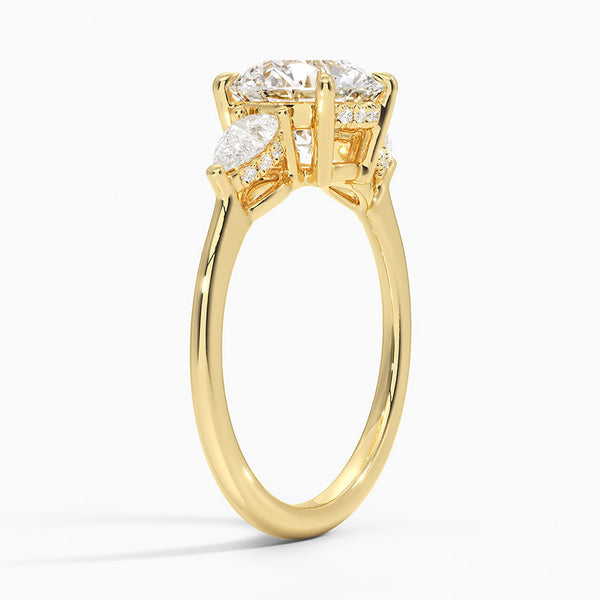 The Virelle Bloom ring features a brilliant round diamond flanked by marquise and pavé-set stones, evoking the soft, organic elegance of blossoming petals.