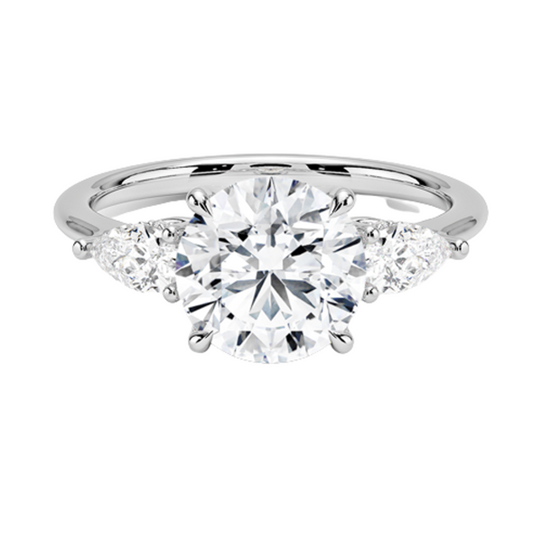 The Virelle Bloom ring features a brilliant round diamond flanked by marquise and pavé-set stones, evoking the soft, organic elegance of blossoming petals.