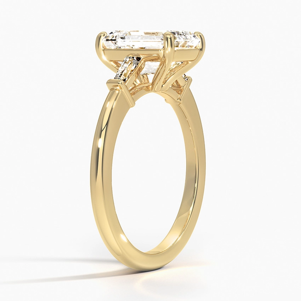 The Solmaris Crest ring showcases a commanding emerald-cut diamond framed by trapezoid side stones, exuding modern elegance and architectural beauty.